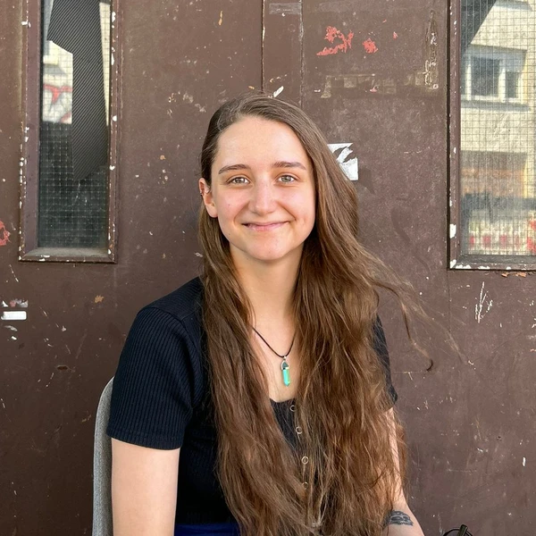 Foto von Elsa Lefering, Sozialarbeiterin, Beratung vor einer alten braunen Tür eines Lastenaufzugs